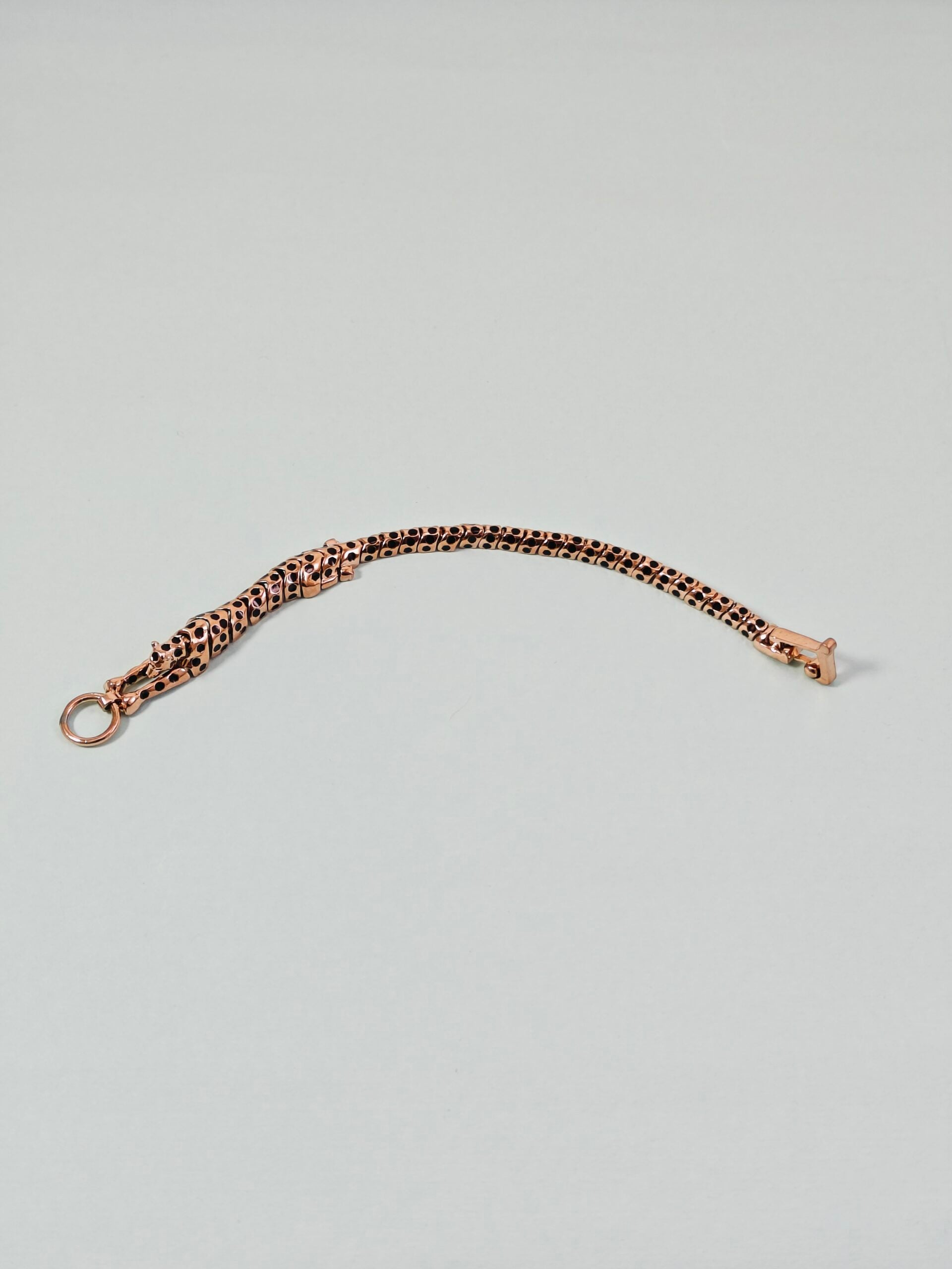 Rose gold chain bracelet on a light gray background